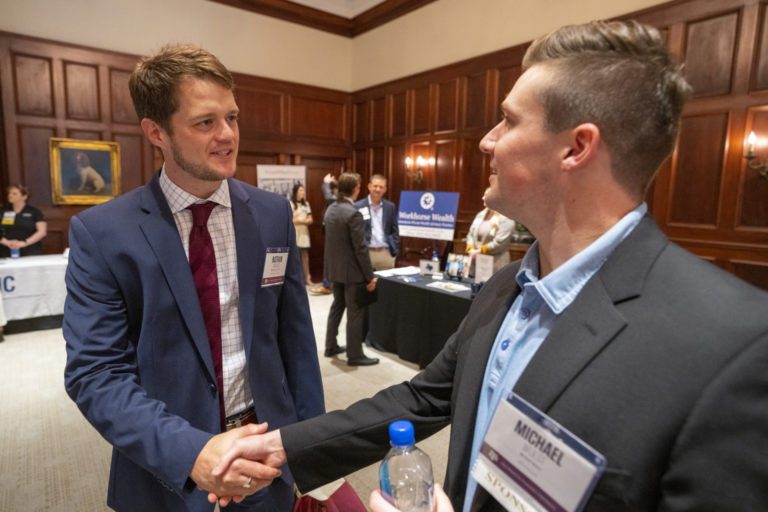 Two men shaking hands at a Finance event