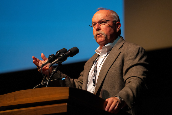 David Anderson, Ph.D., standing at a lecturn.