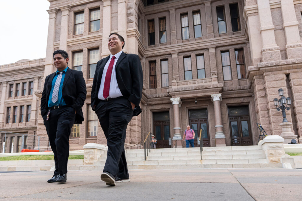 two male students in business attire leaving the state capital building in Austin, TX.